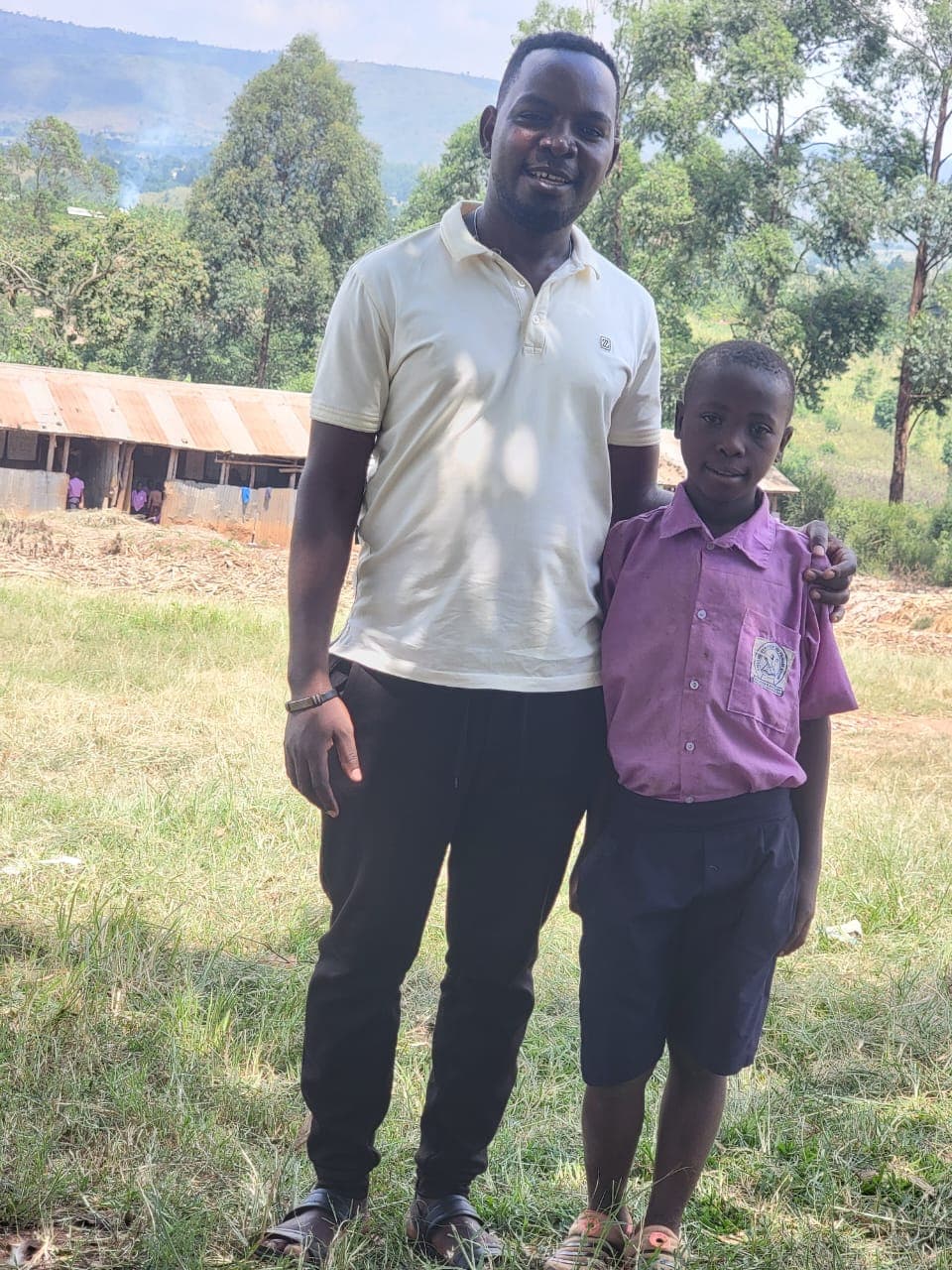 A Reaching Hands Foundation team member with a pupil in Uganda