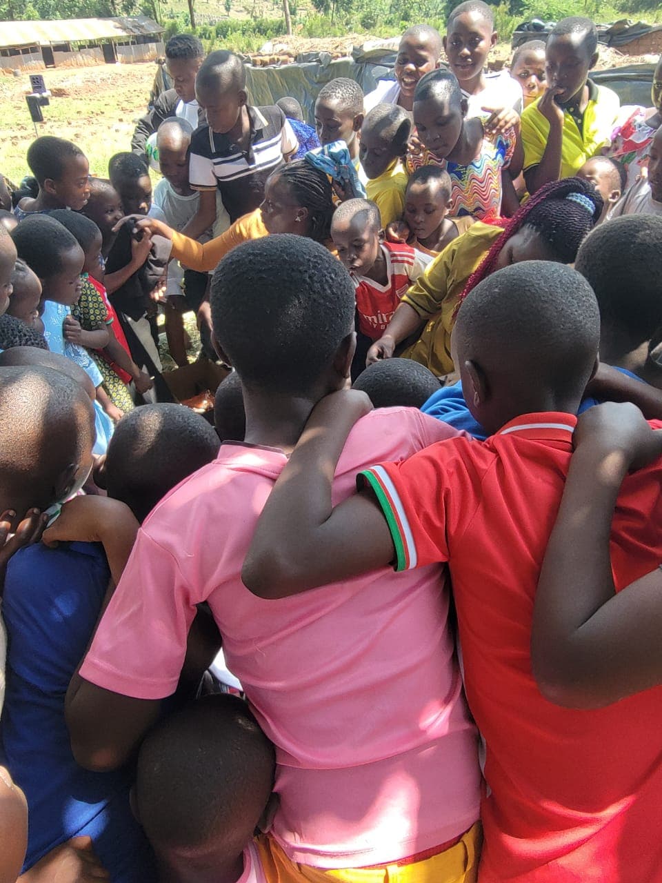 Children gathered around during a Reaching Hands outreach day in Uganda